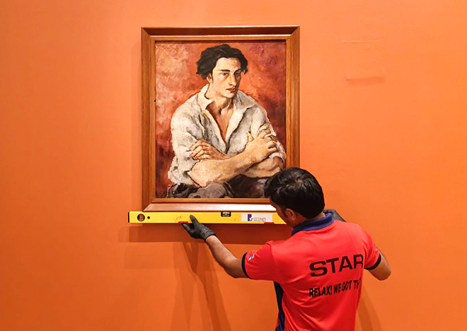 Star Worldwide team member handling a priceless artwork during installation for the "Indian Masters of Modern Art" exhibition at Bihar Museum